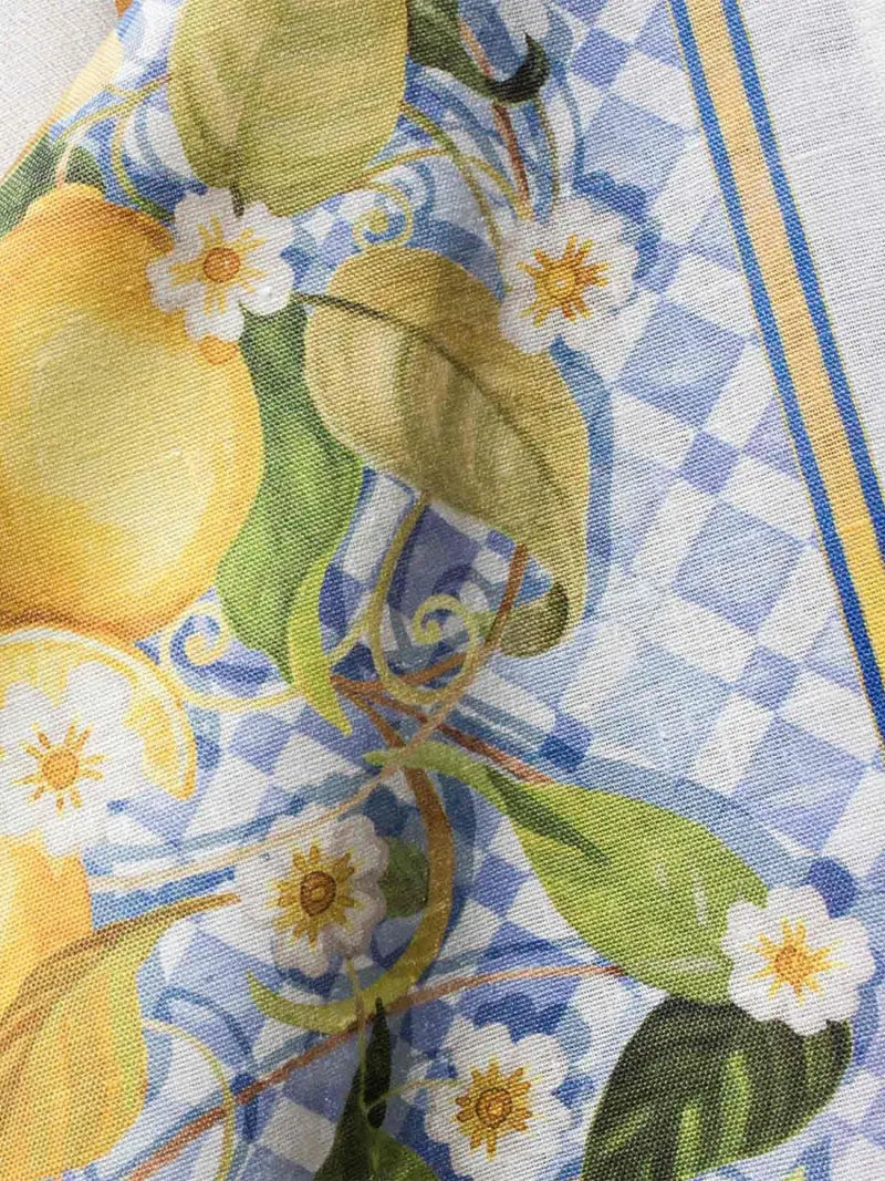 Close-up of a fabric with lemon and flower pattern on a checkered background