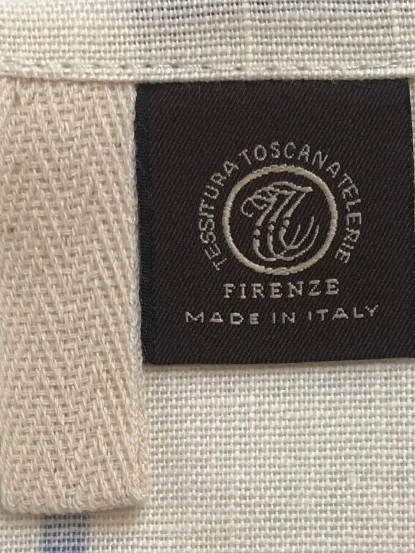 Close-up of Tessitura Toscana Telerie (Firenze) label on fabric with 'Made in Italy' text.