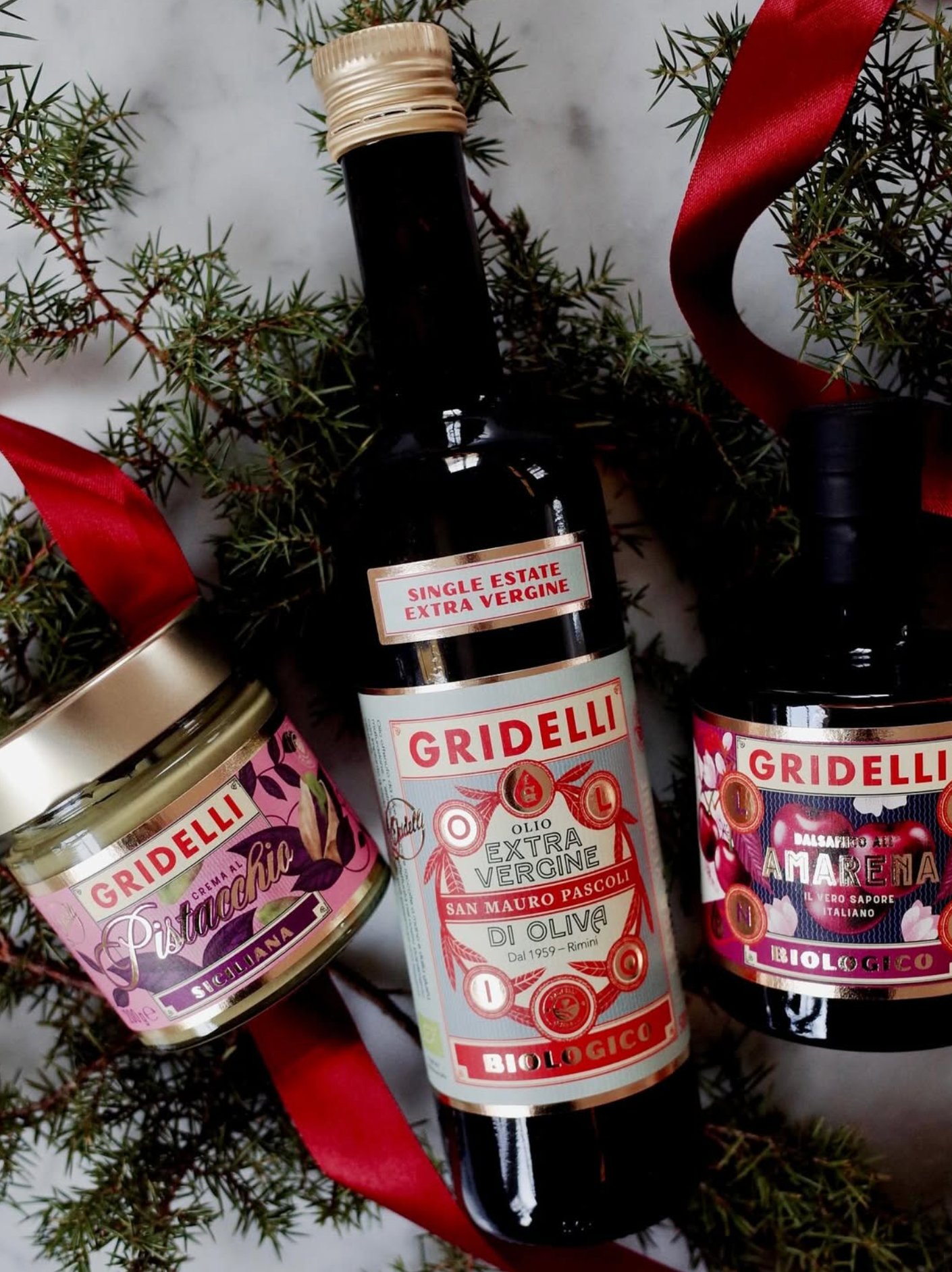 Gridelli olive oil bottle with a jar and a bottle of amarena cherry on a decorative background