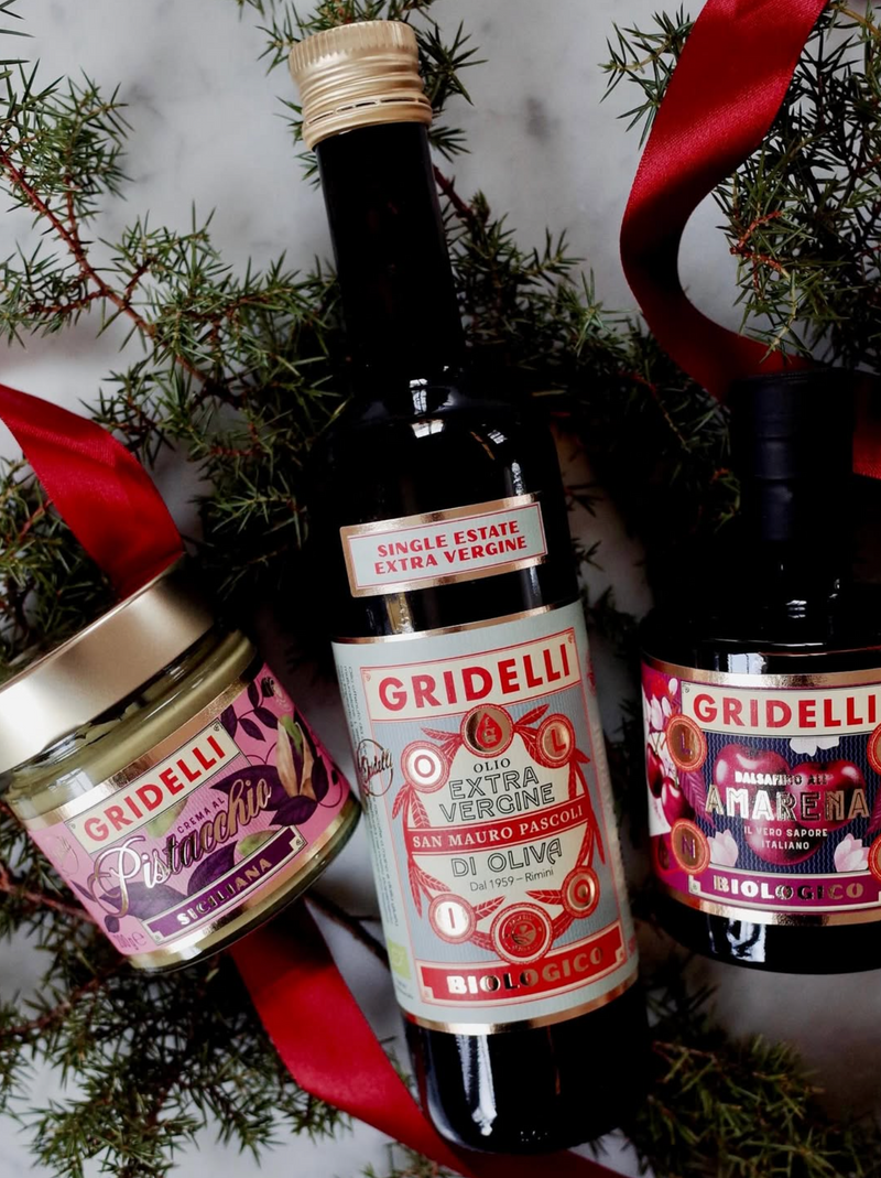 Gridelli olive oil bottle with a jar and a bottle of amarena cherry on a decorative background
