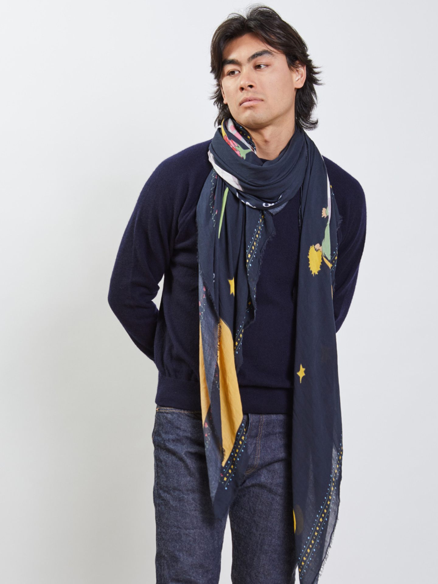 Person wearing a dark blue sweater and patterned scarf against a white background