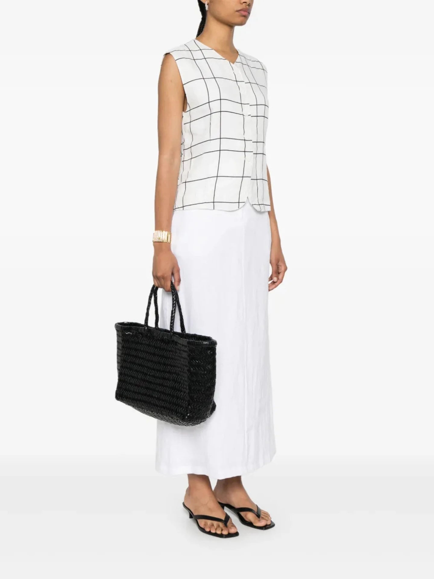 Woman holding a black woven handbag against a white background