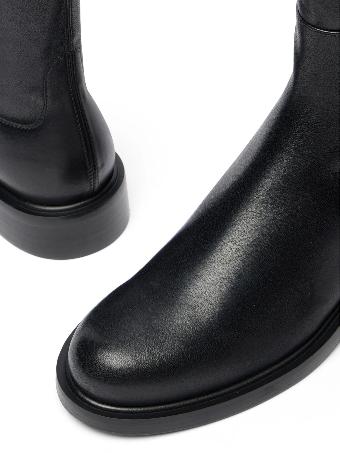 Close-up of black leather boots on a white background