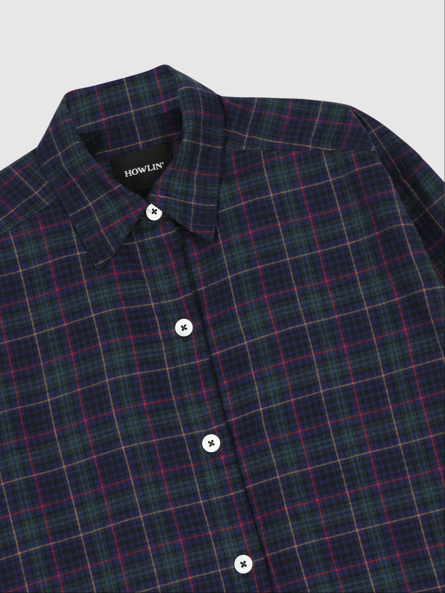 Plaid shirt with visible brand name on a light gray background