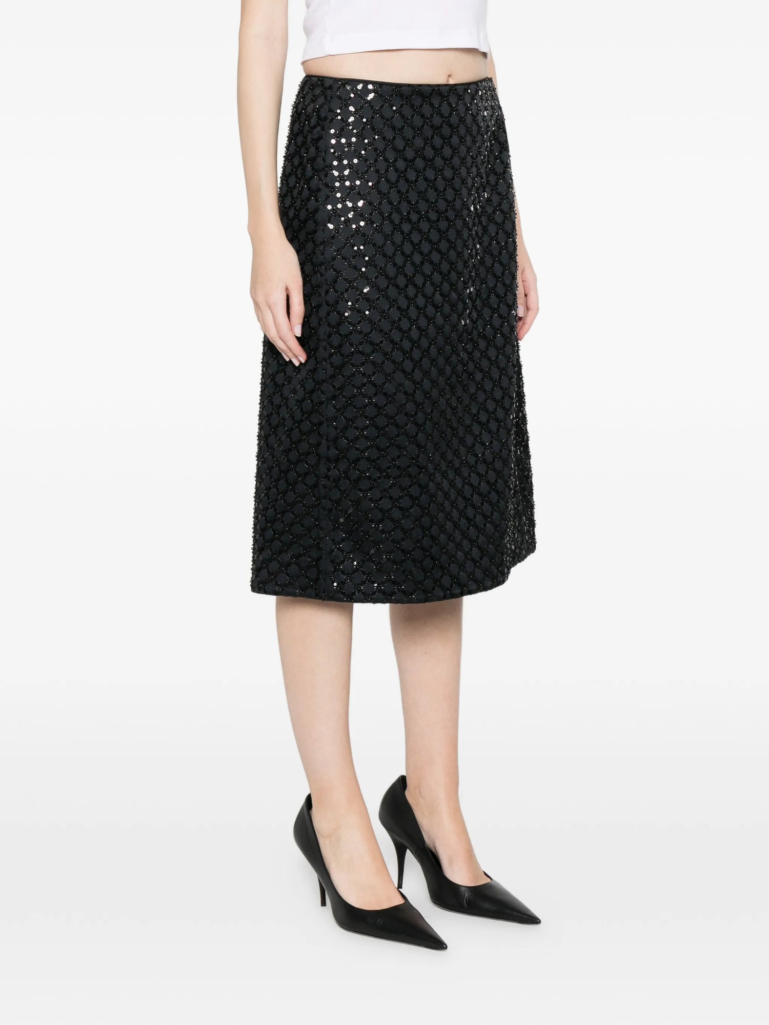 Black sequin skirt worn by a person on a white background