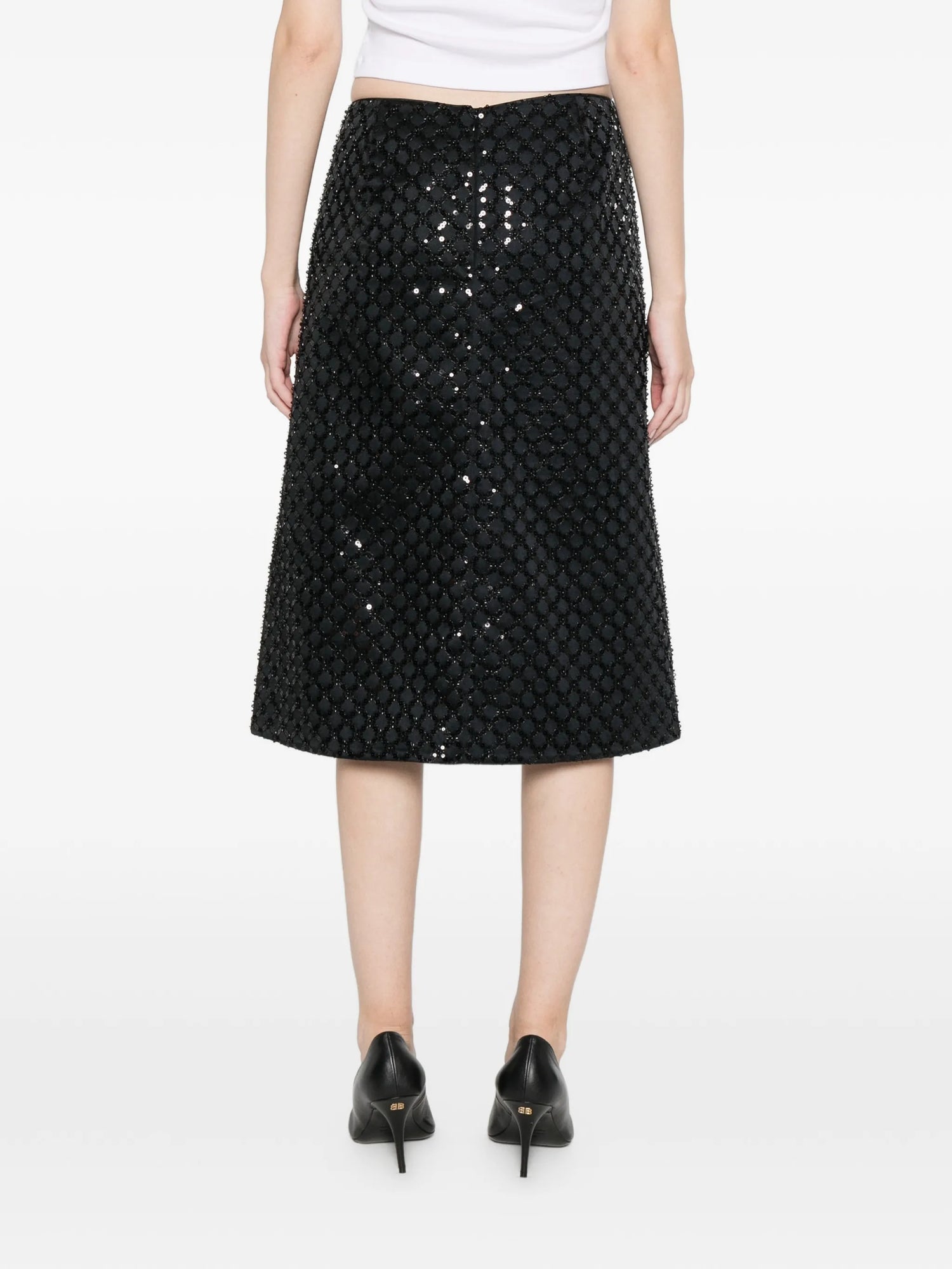 Black sequin skirt worn by a person on a white background