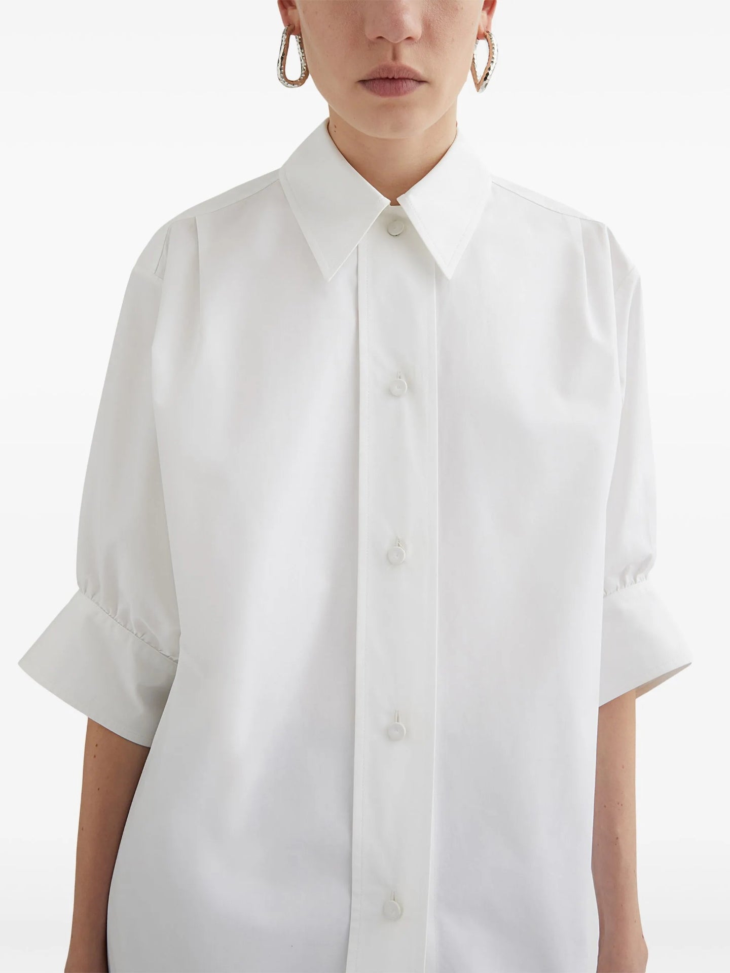White short-sleeve shirt worn by a person on a white background