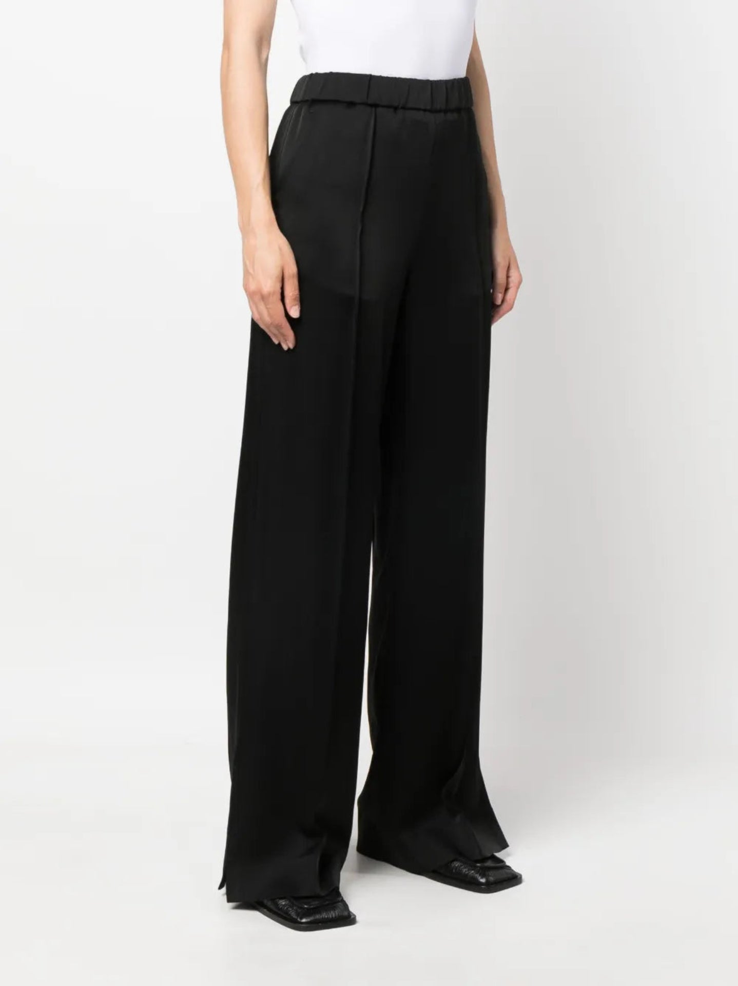 Black wide-leg pants worn by a person on a white background