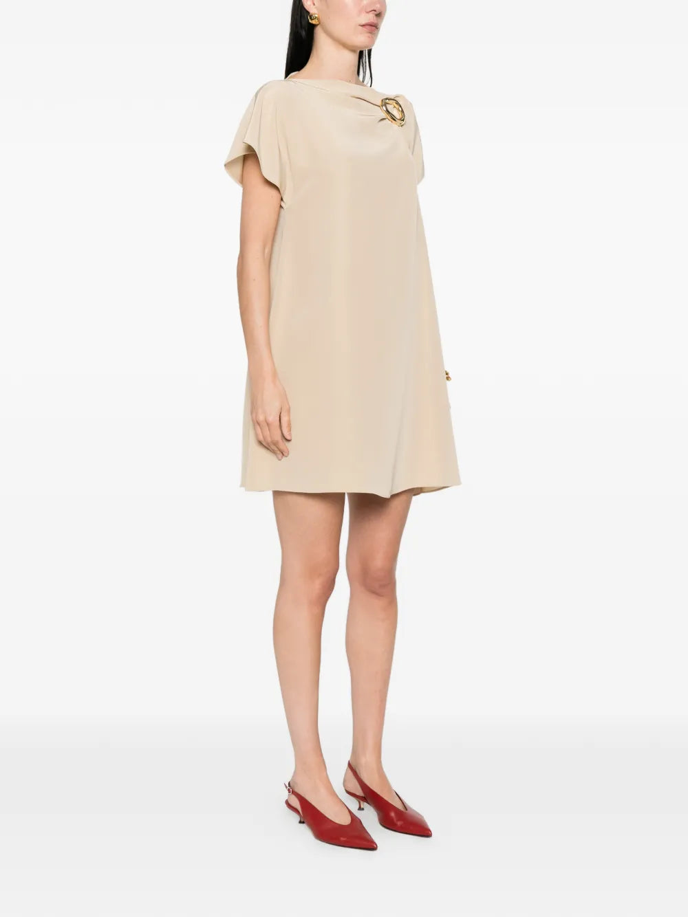 Woman wearing a beige dress with a plain background
