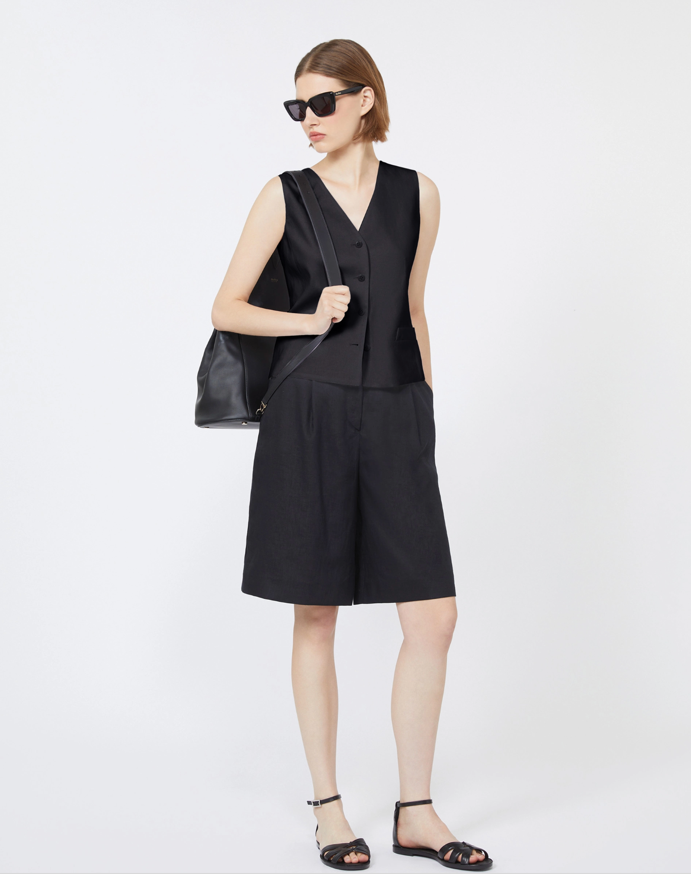 Woman wearing a black outfit with black shorts and vest