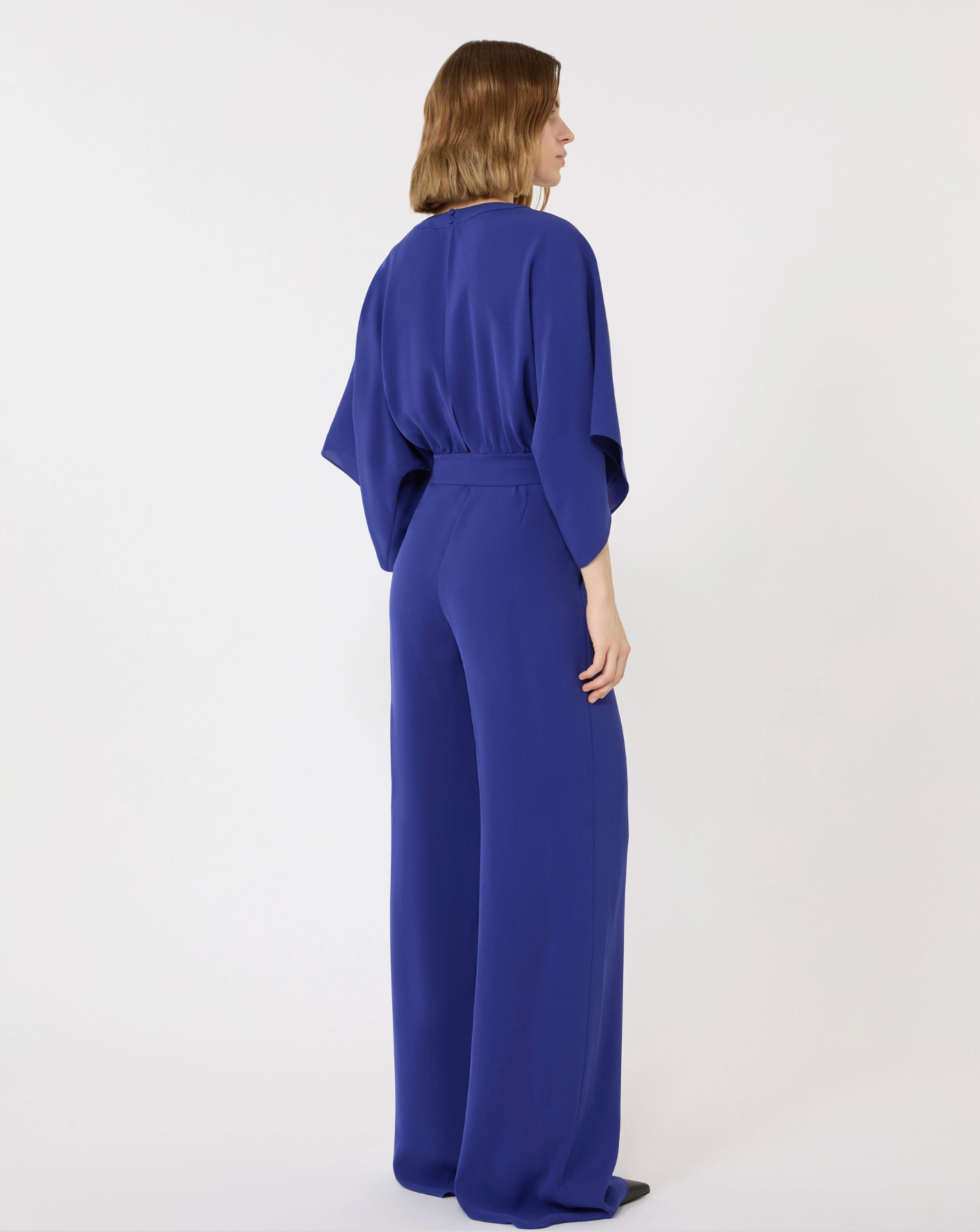 Woman wearing a blue jumpsuit on a white background