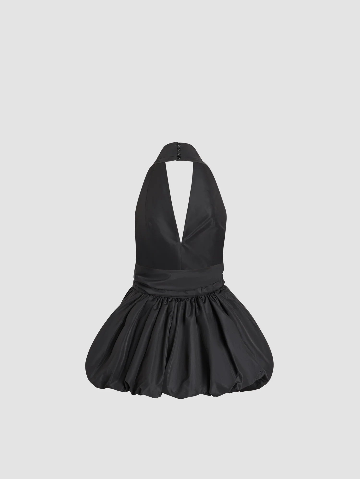 Black halter dress with a pleated skirt on a light gray background
