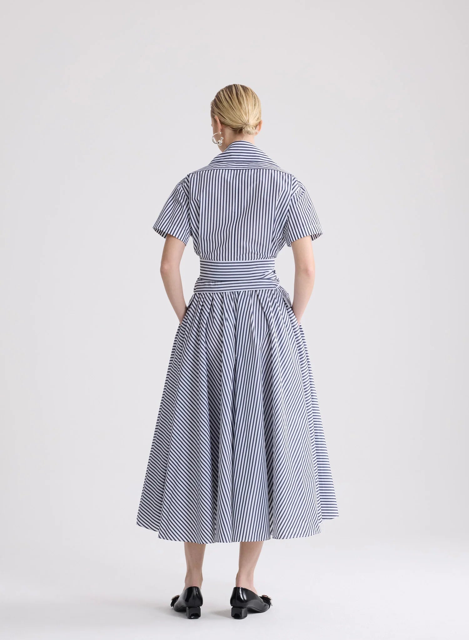 Woman wearing a blue and white striped dress on a white background