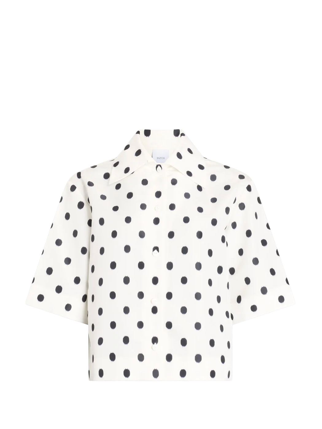 White blouse with black polka dots on a white background