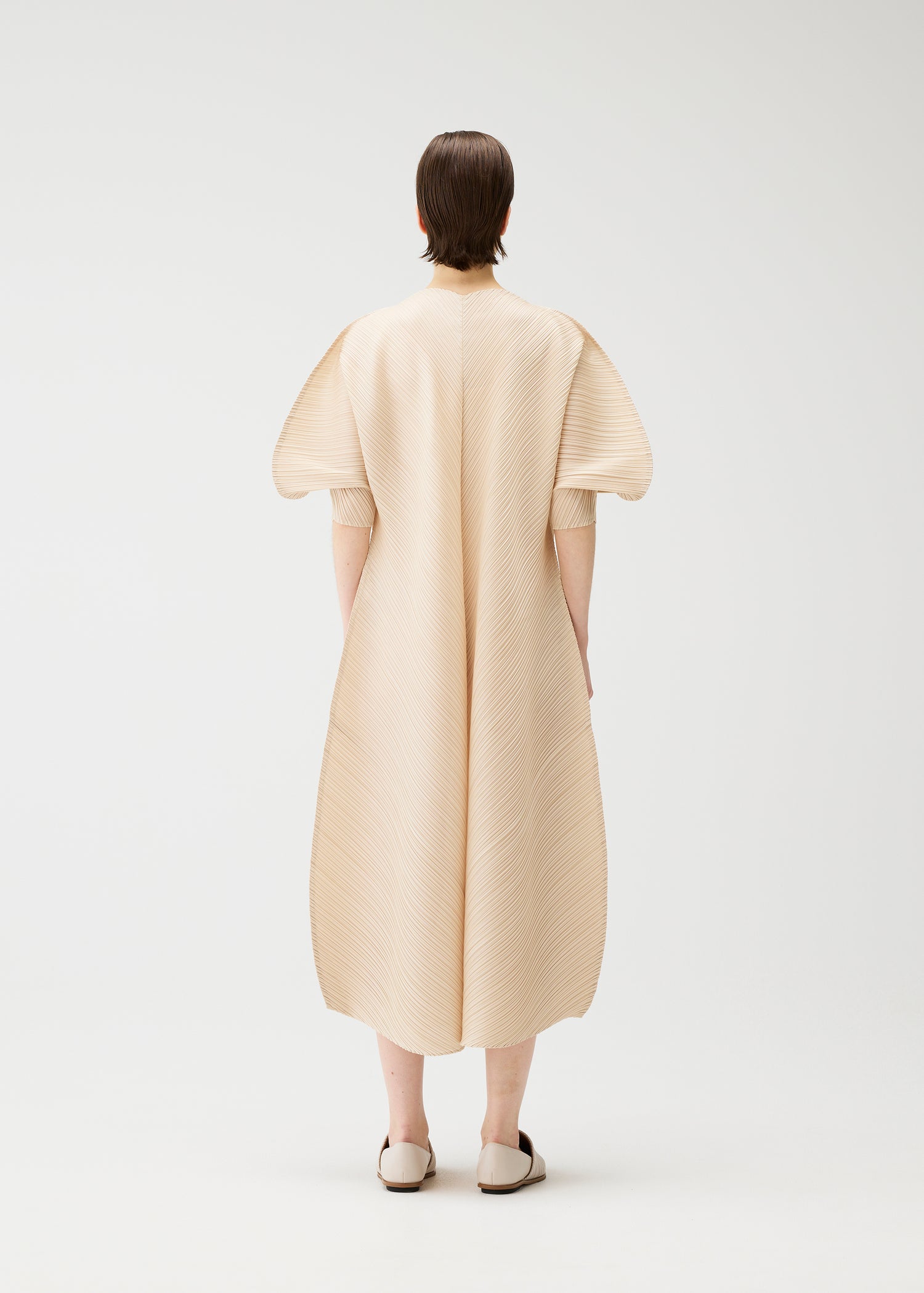 The backside of a model wearing a beige long dress with short balloon sleeves on a white background