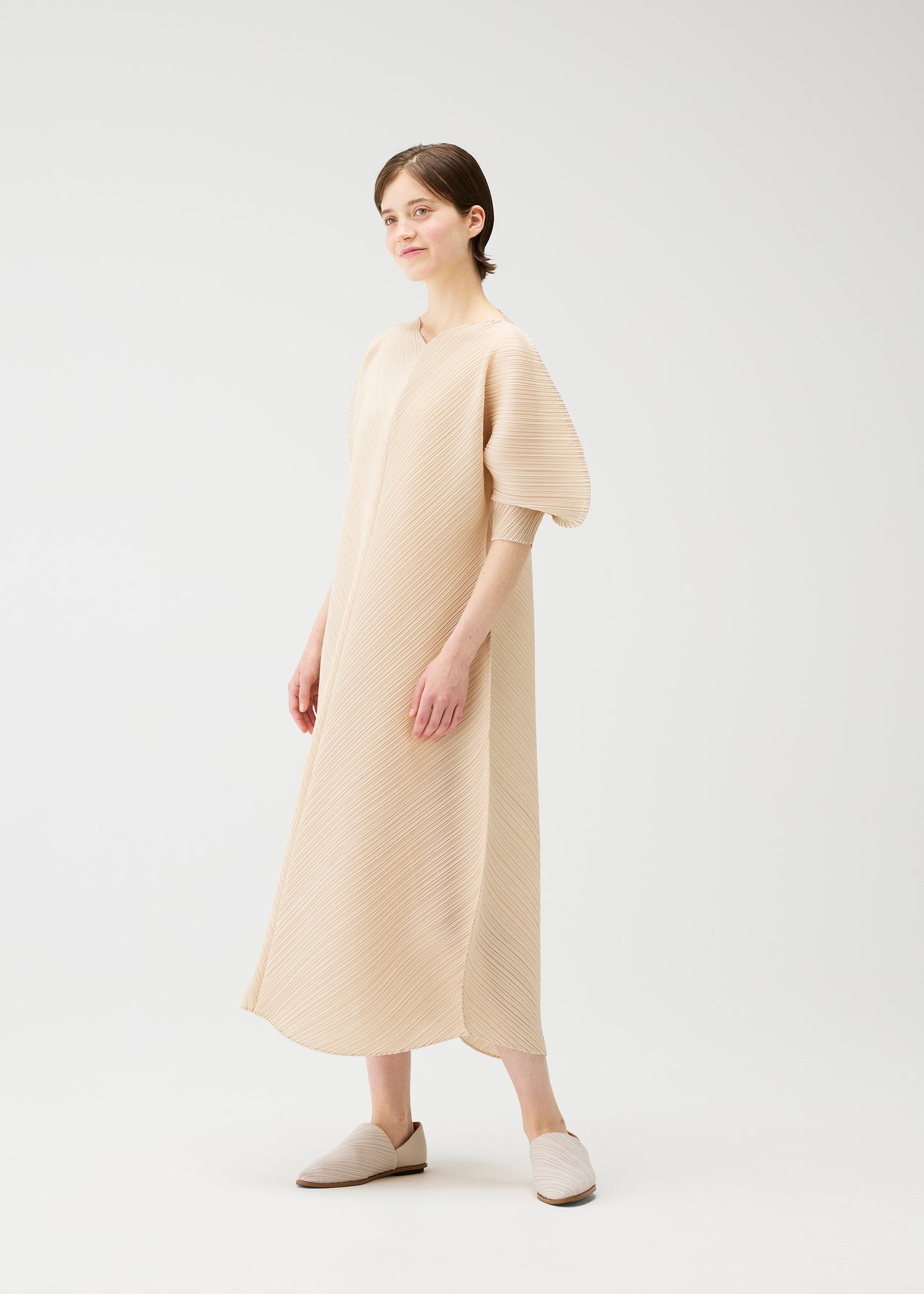 Woman wearing a beige dress on a white background
