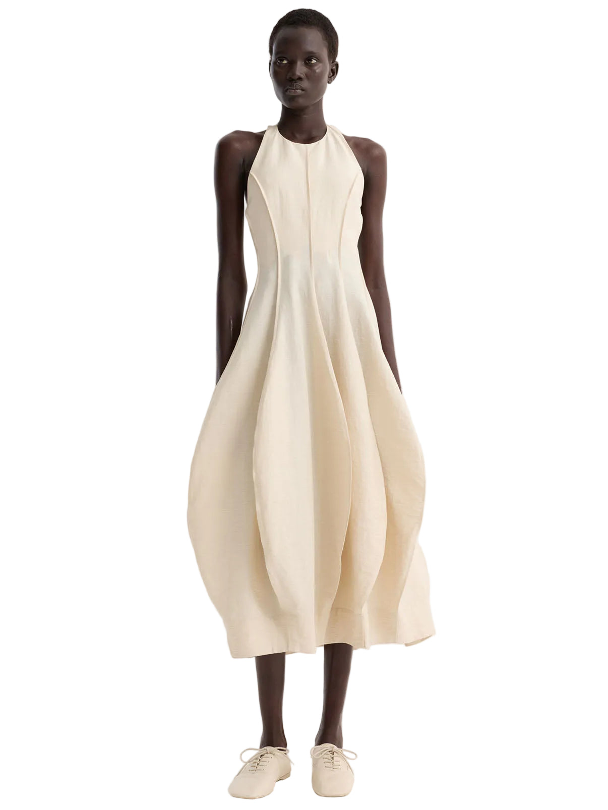 Woman wearing a beige sleeveless dress on a white background