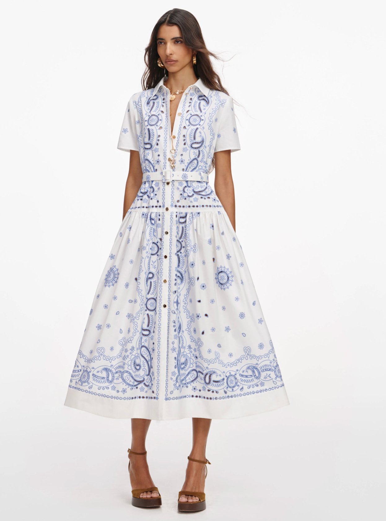 Woman wearing a white dress with blue patterns on a white background