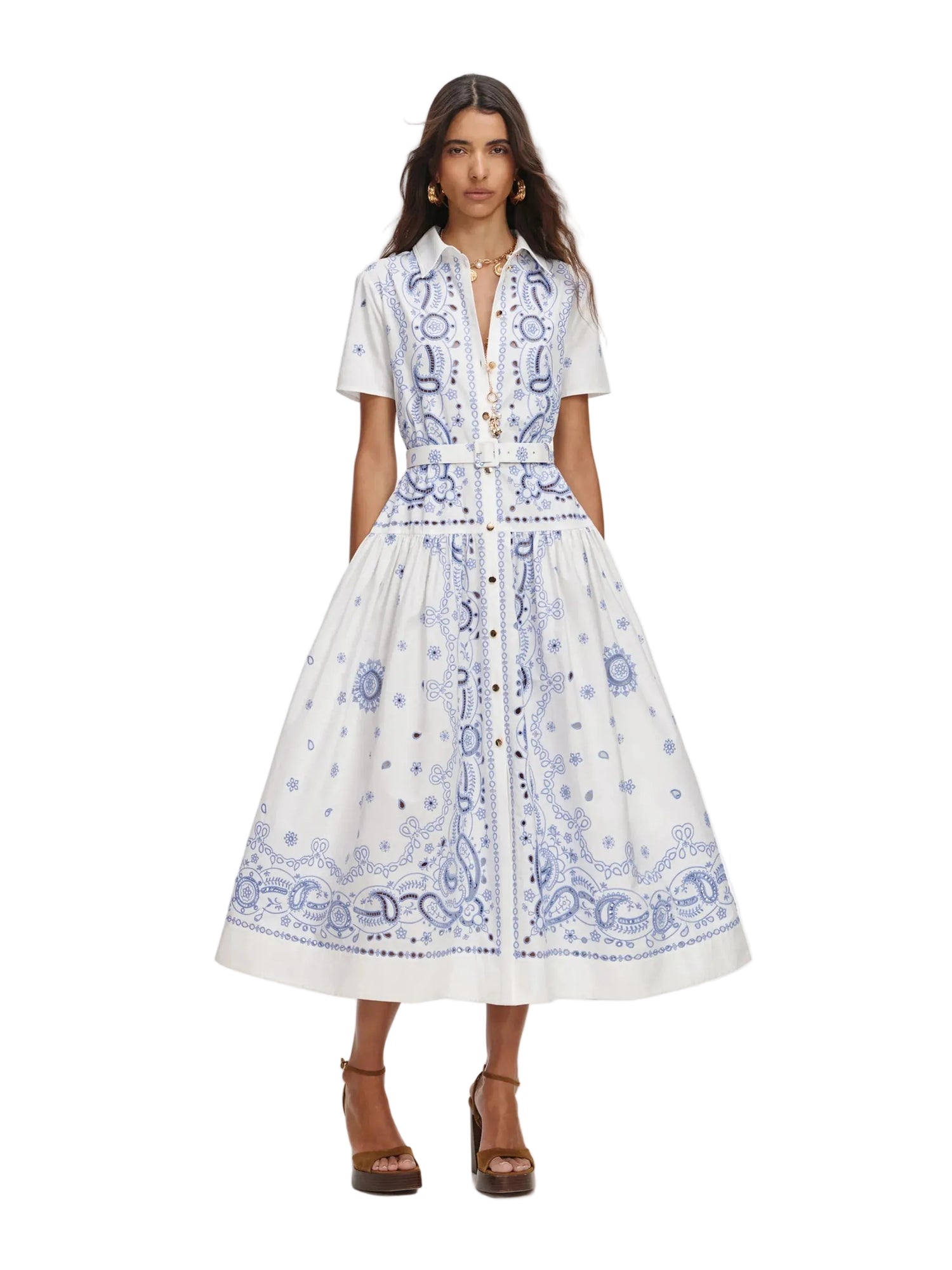 Woman wearing a white dress with blue patterns on a white background