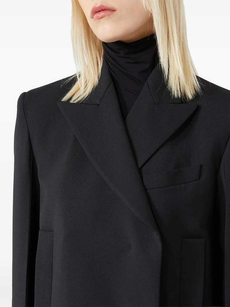 Close-up of a person wearing a black blazer on a white background