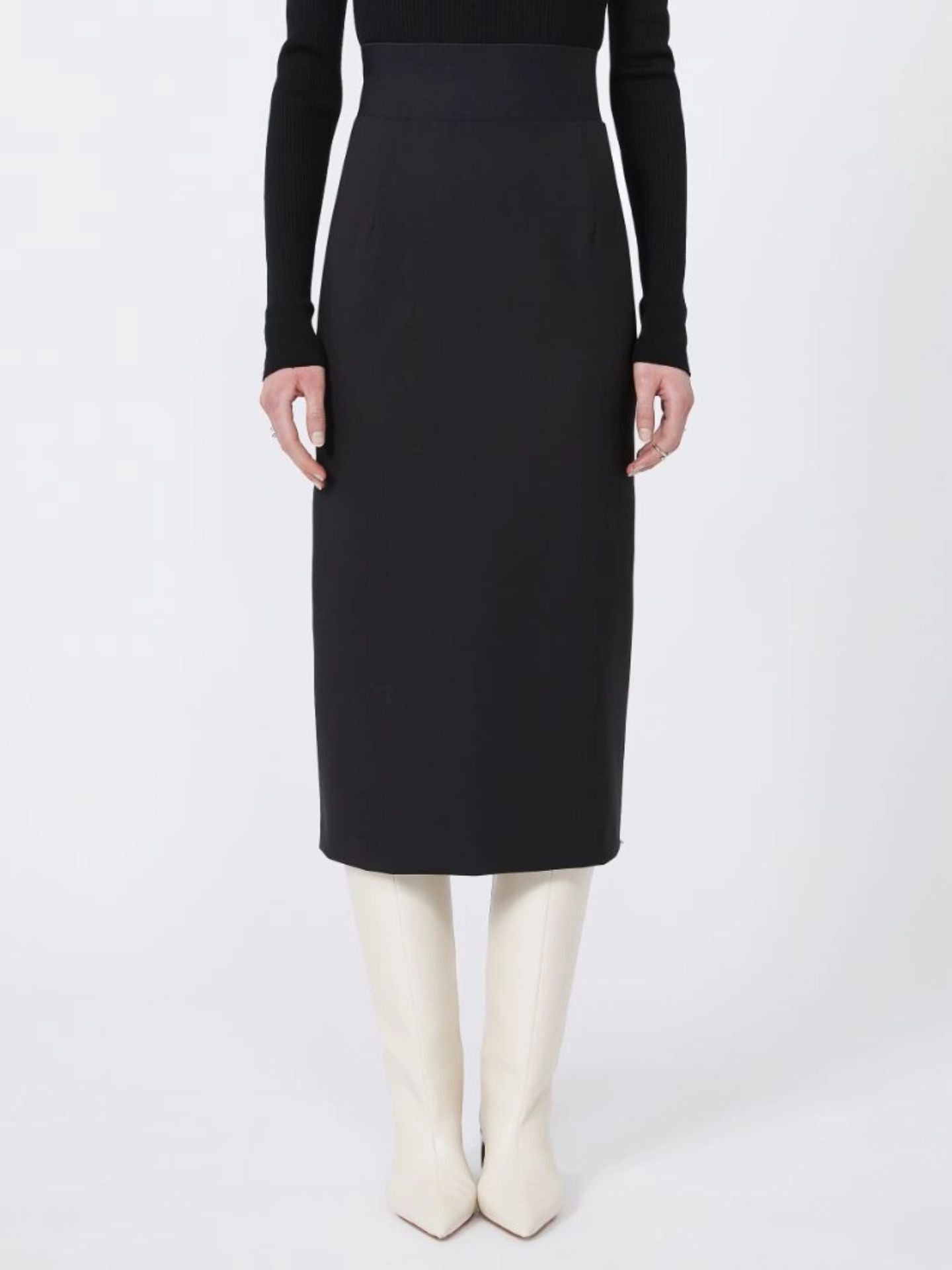 Person wearing a black skirt and white boots on a white background
