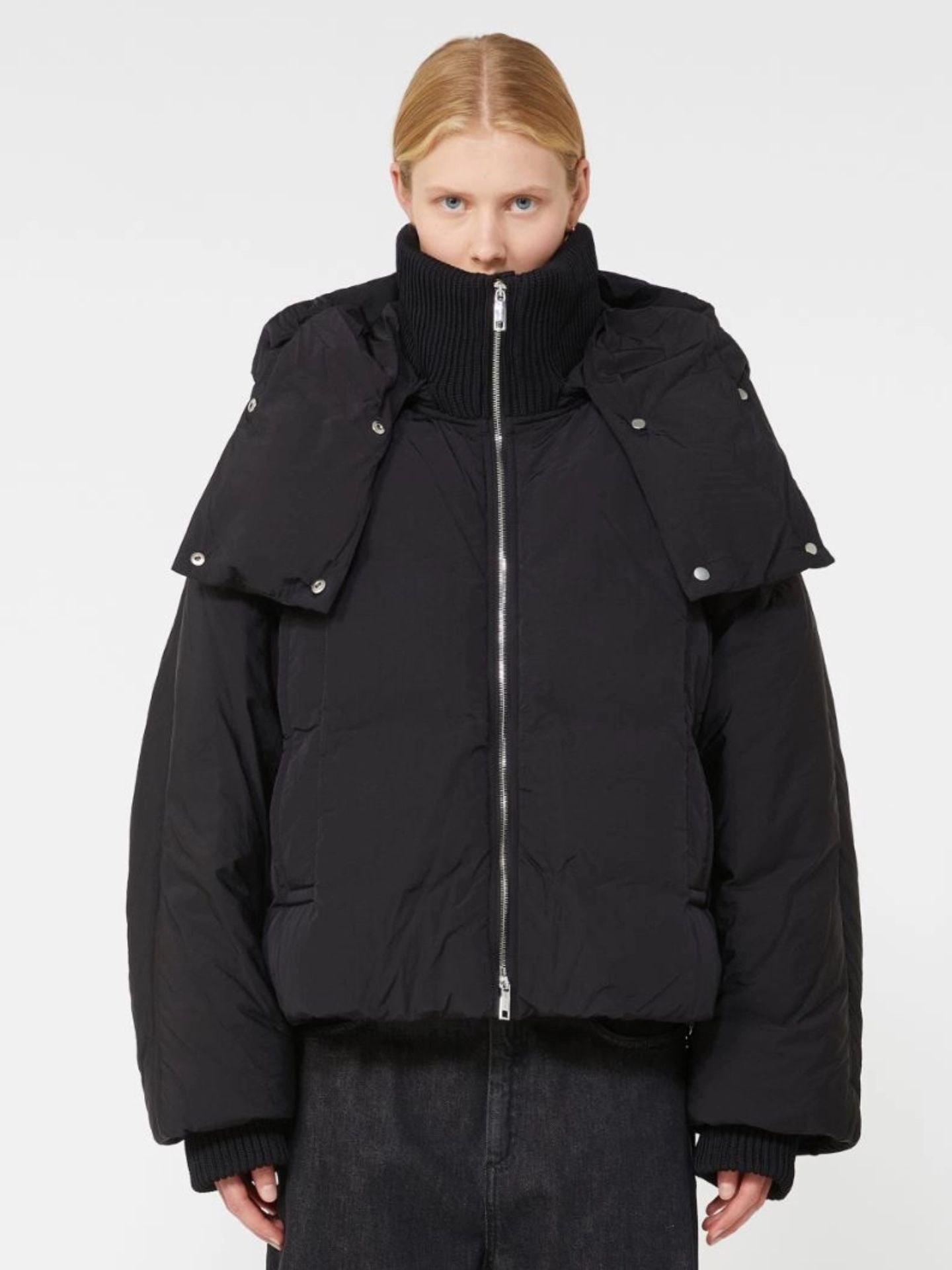 Person wearing a black puffer jacket on a white background
