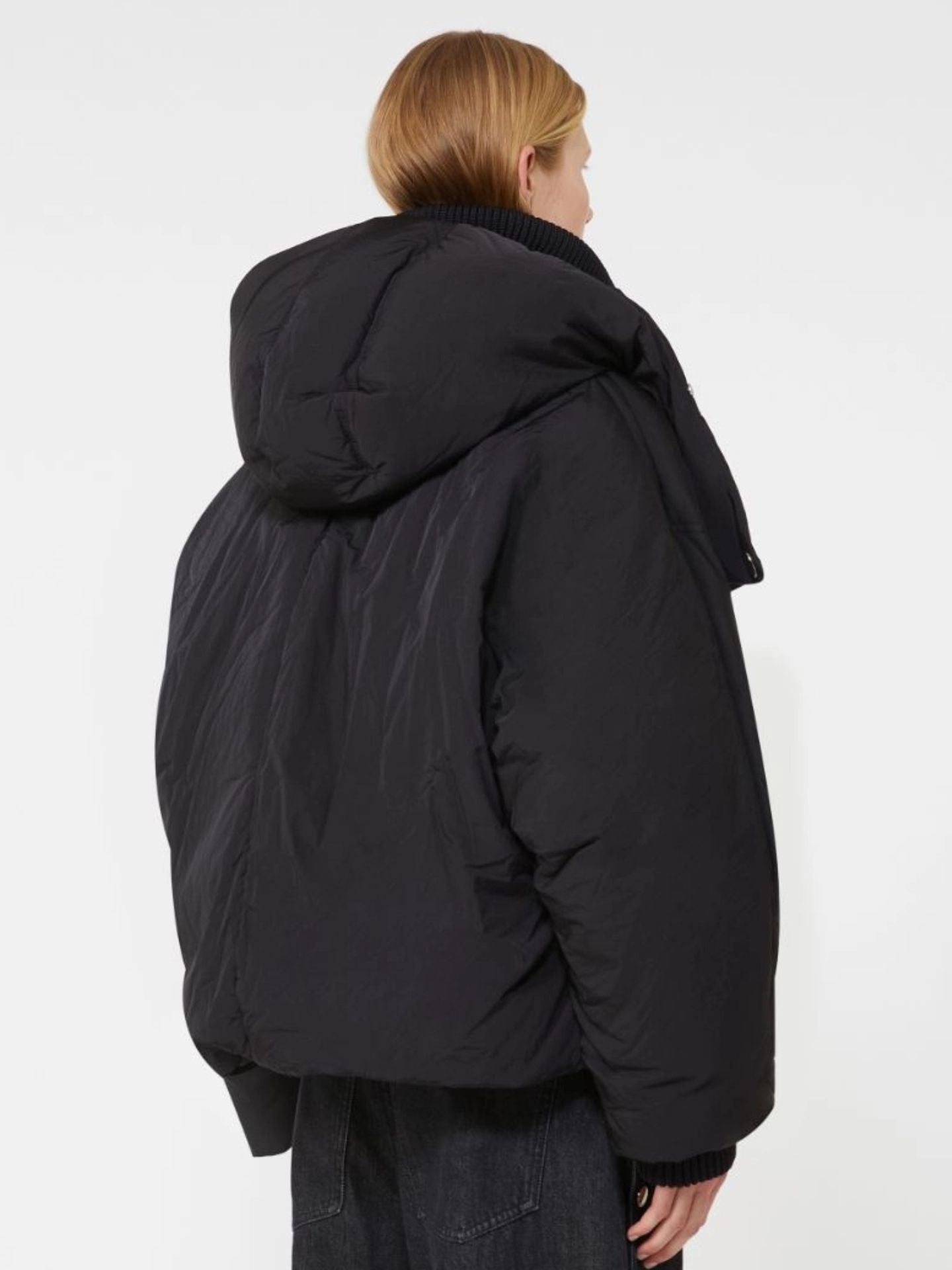 Person wearing a black puffer jacket on a white background