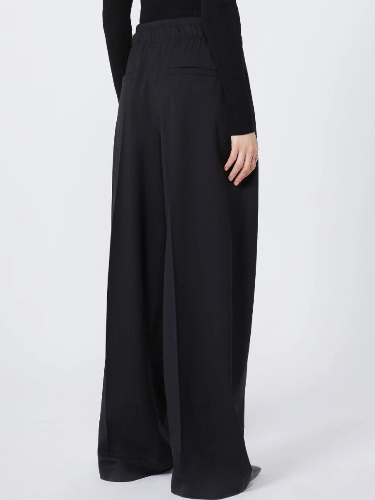 Black wide-leg pants worn by a person on a white background