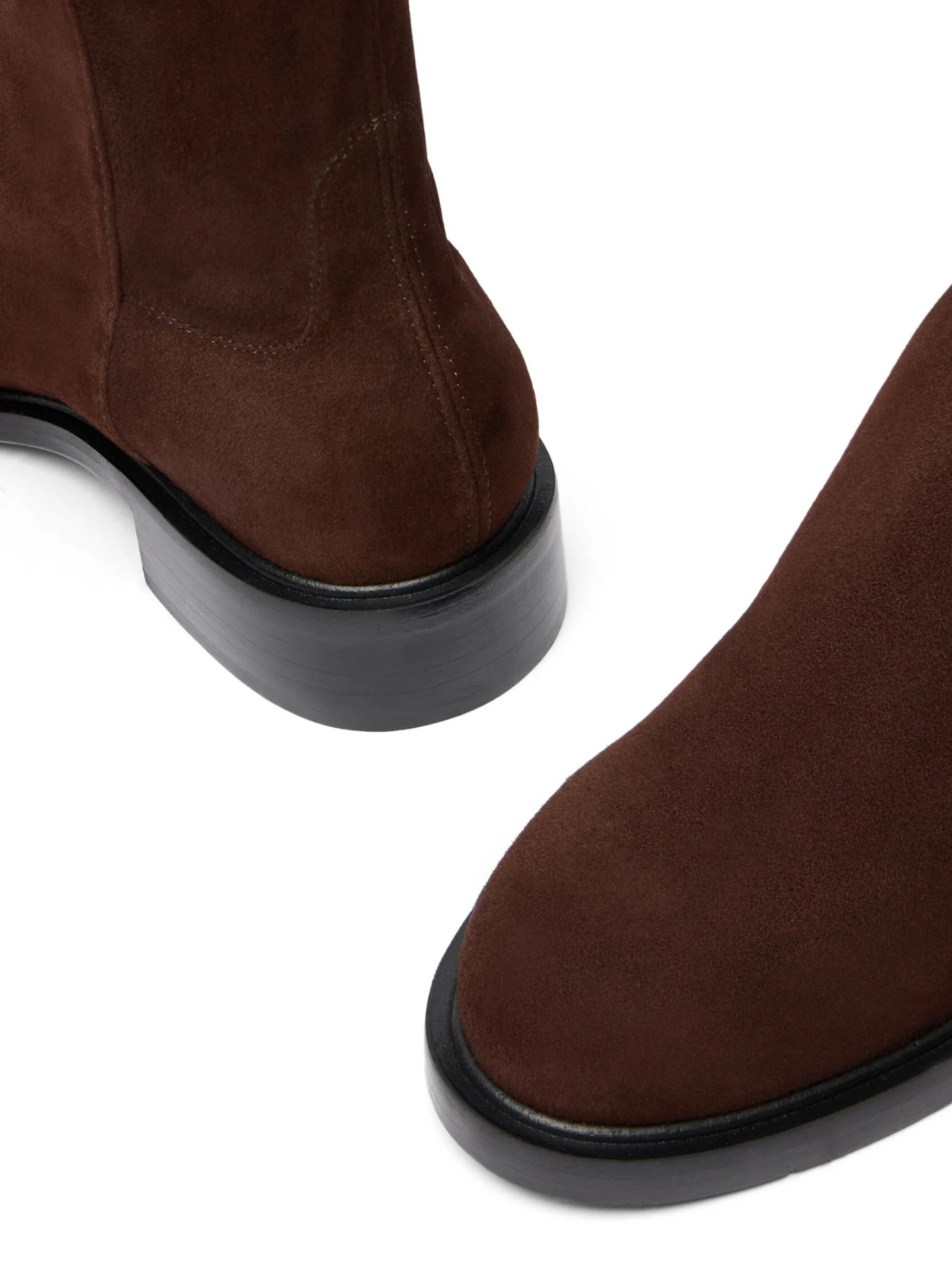 Brown suede boots with black soles on a white background