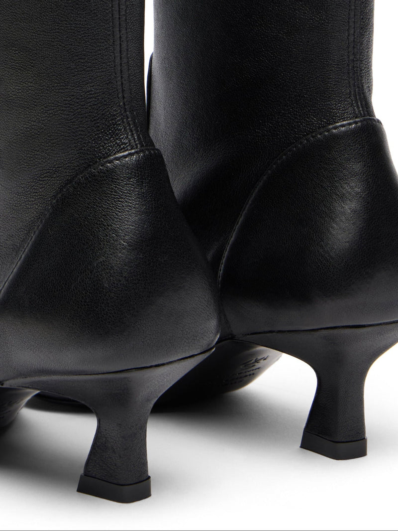 Black knee-high boots with thin heels on a white background