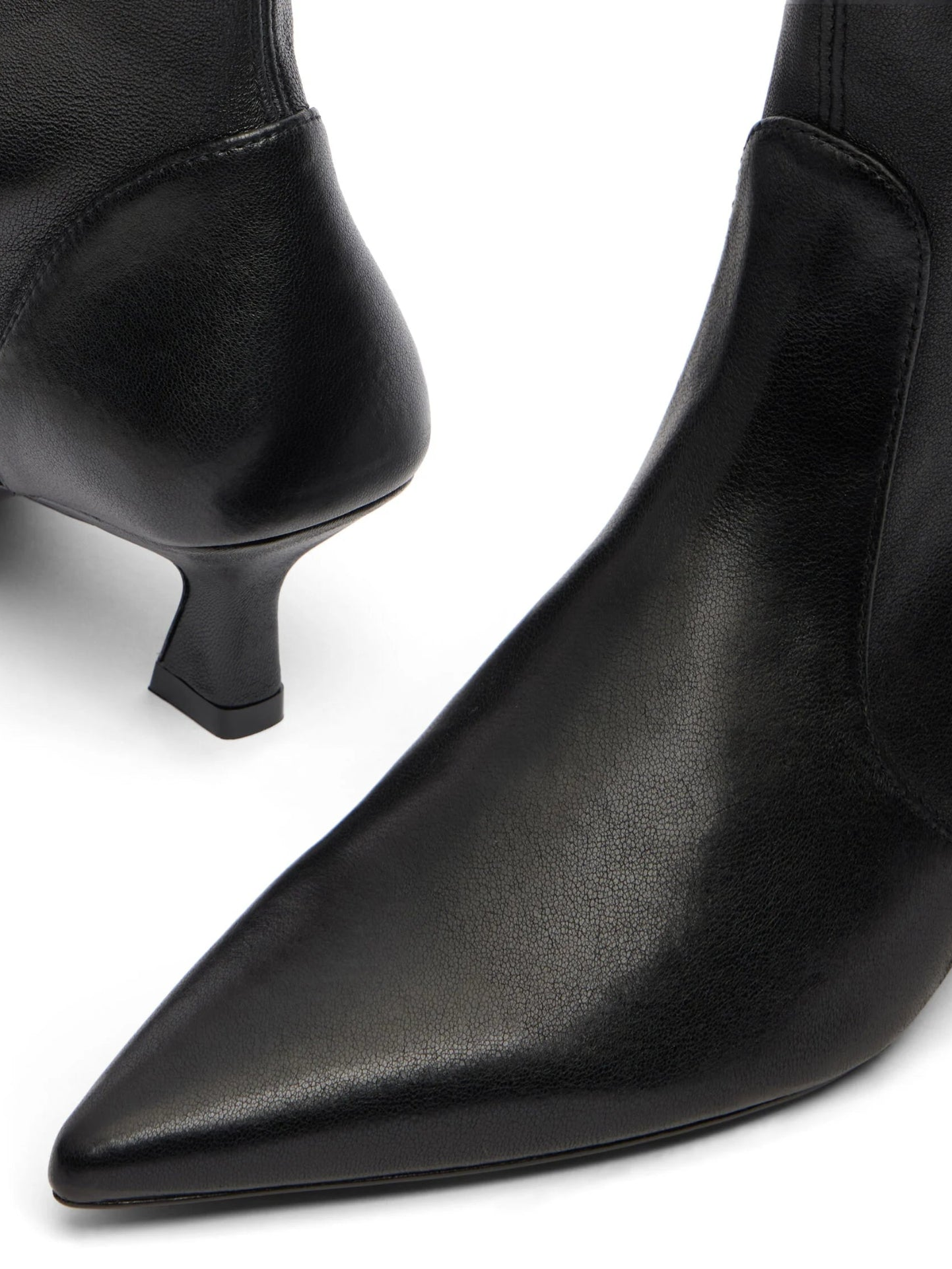 Black leather ankle boots with pointed toes and thin heels on a white background