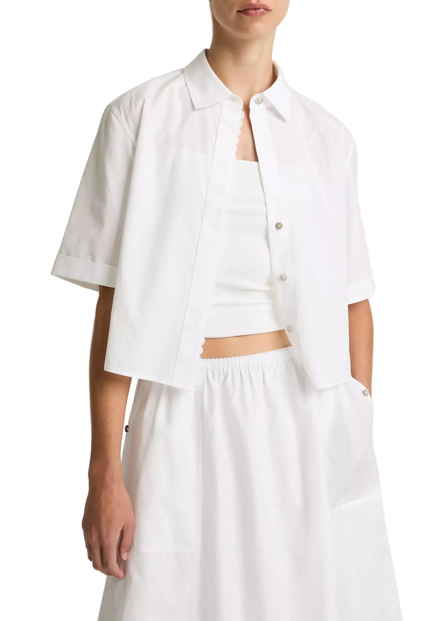 Person wearing a white outfit with a plain background