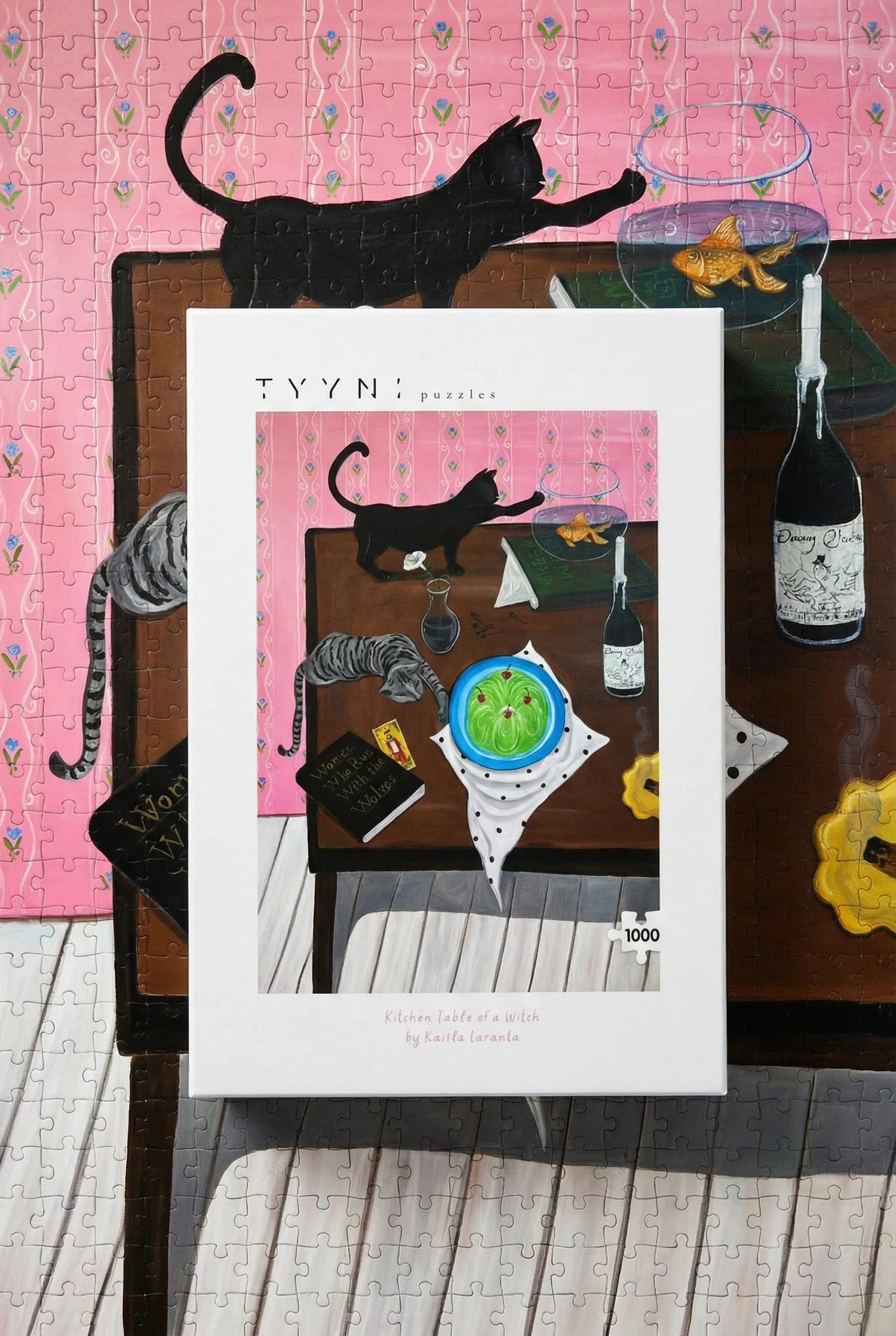 Framed artwork of a cat at a dinner table with a pink background