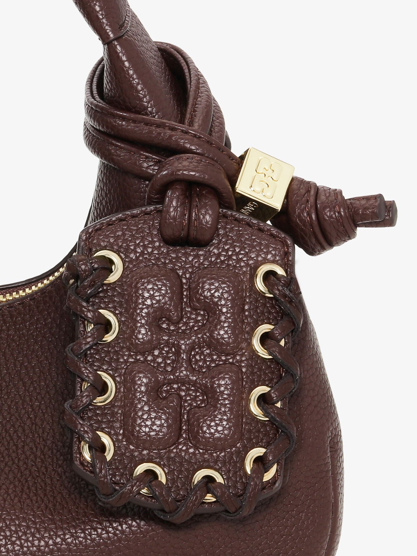 Close-up of a brown leather handbag with gold accents on a white background