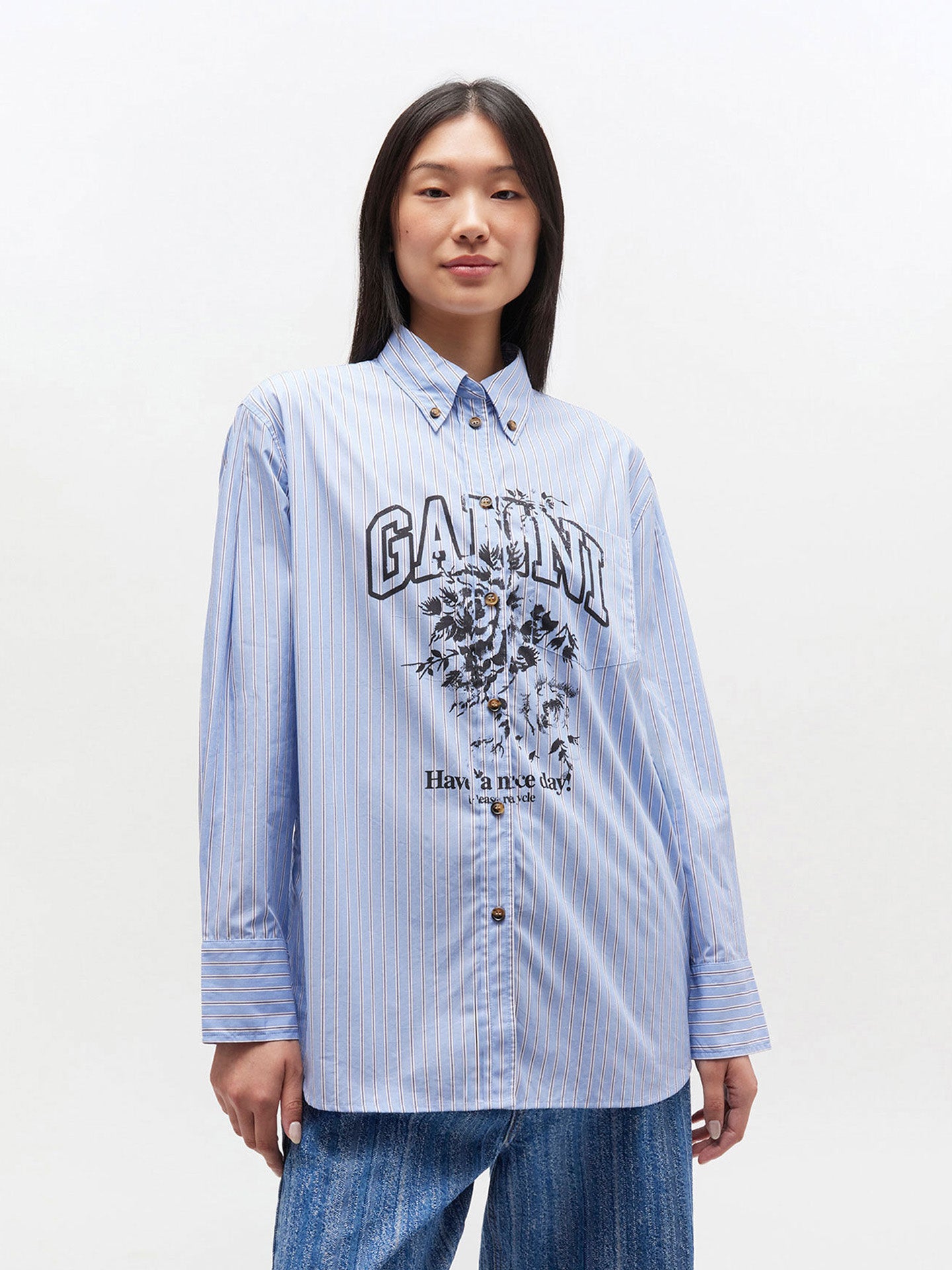 Person wearing a light blue striped shirt with a graphic design on a white background