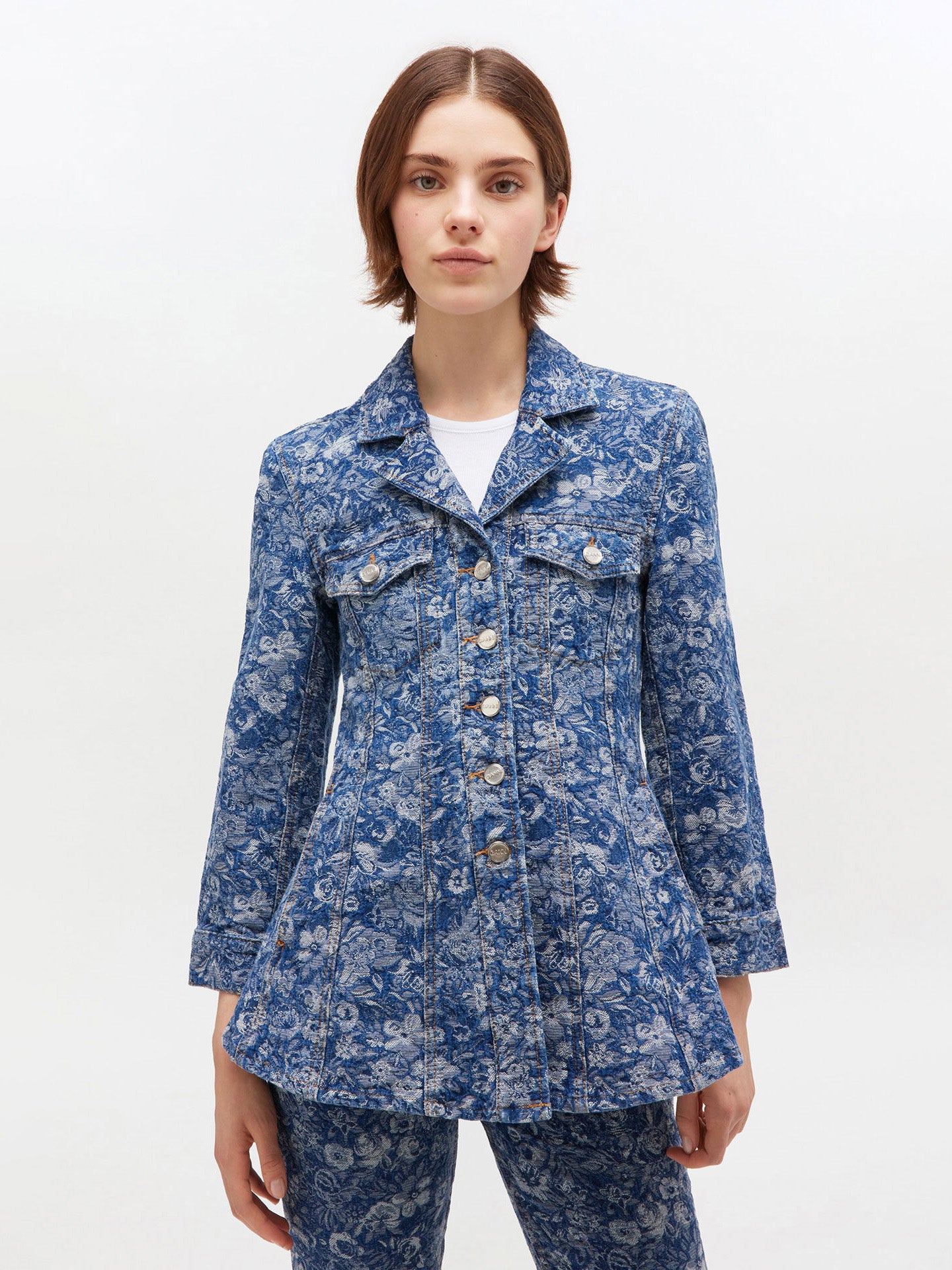 Woman wearing a blue floral jacket on a white background