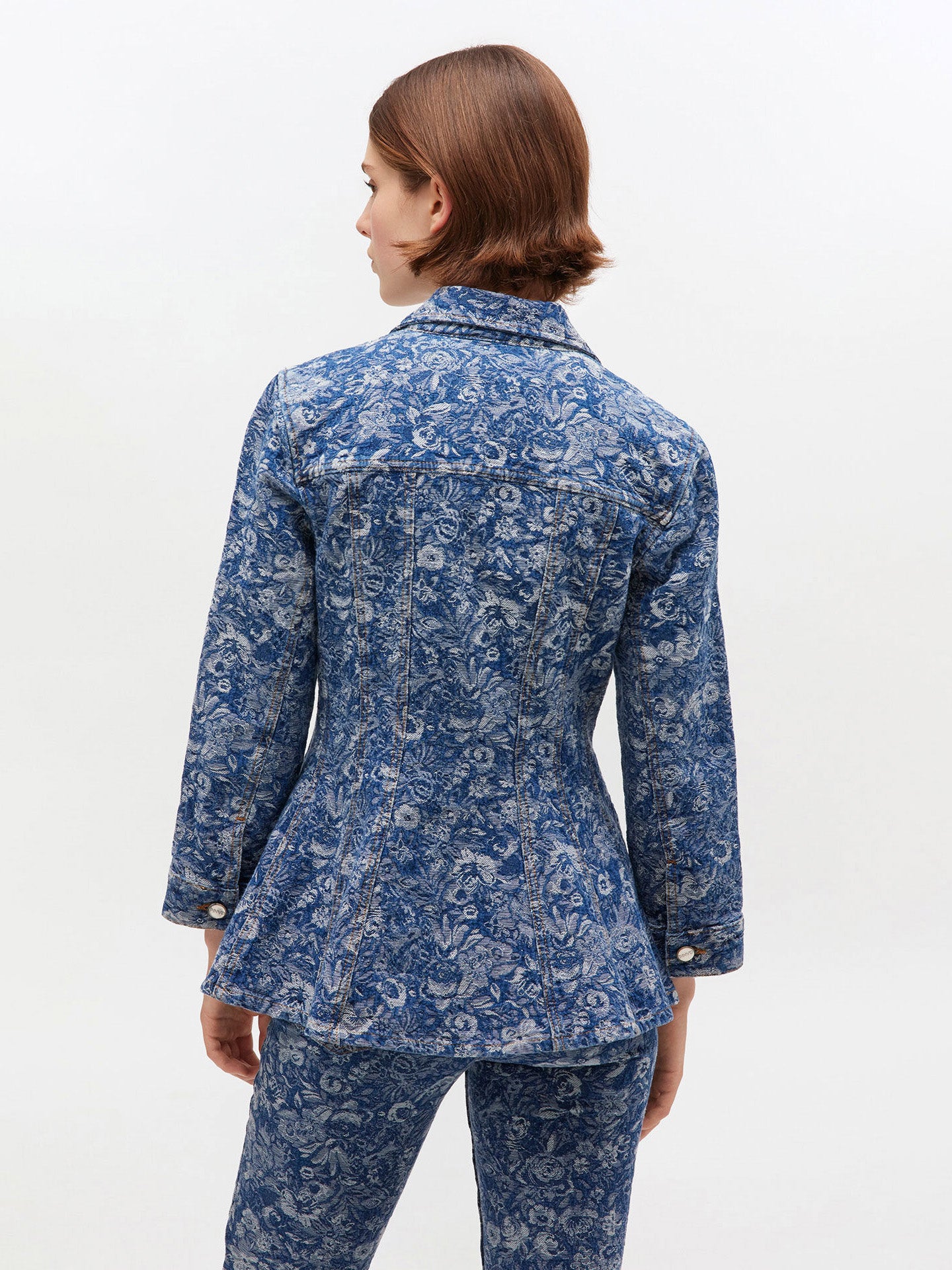 Woman wearing a blue floral patterned outfit on a white background