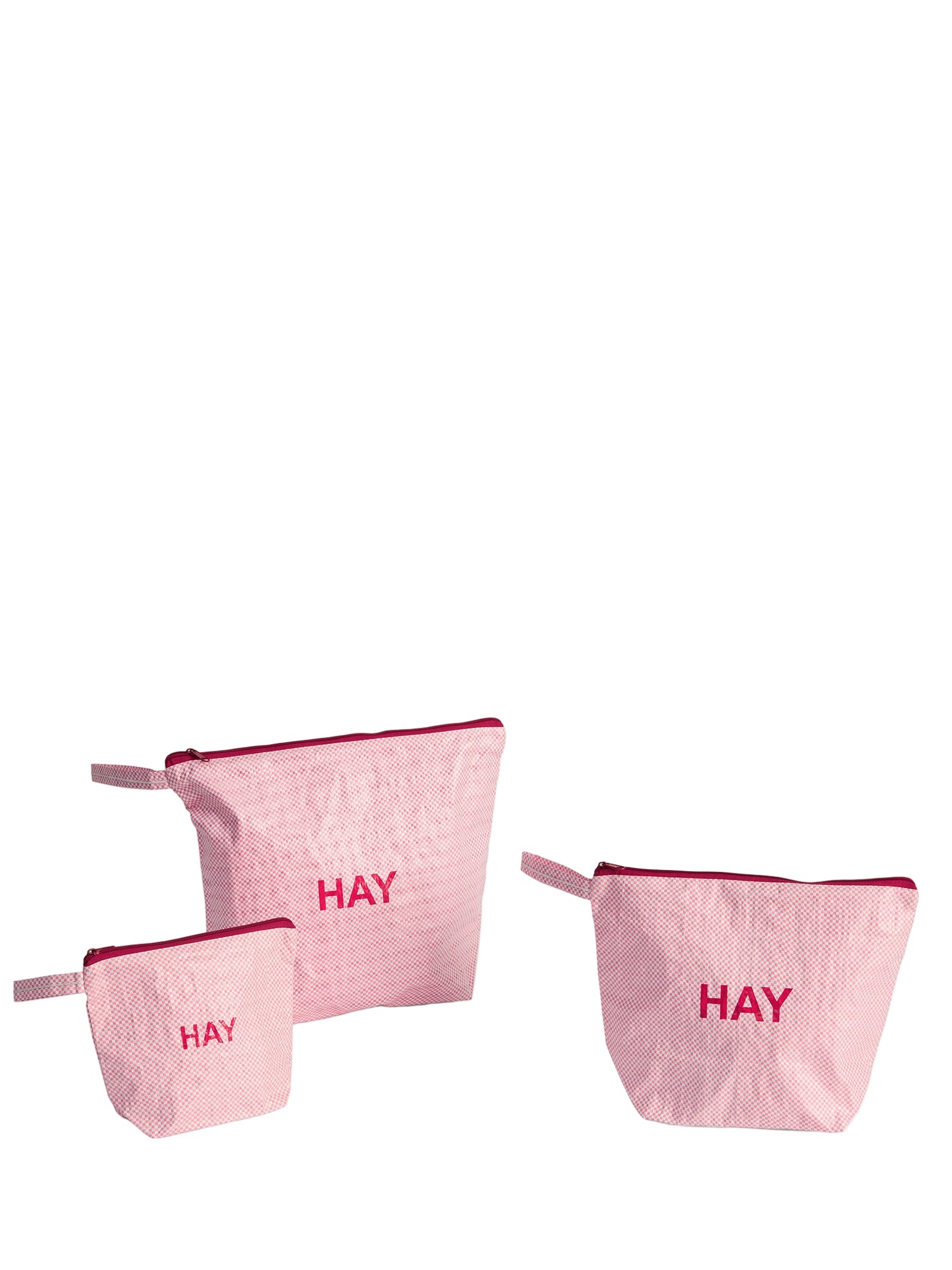 Set of three pink pouches with 'HAY' text on a white background