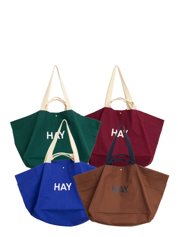 Four colorful tote bags with 'HAY' branding on a white background