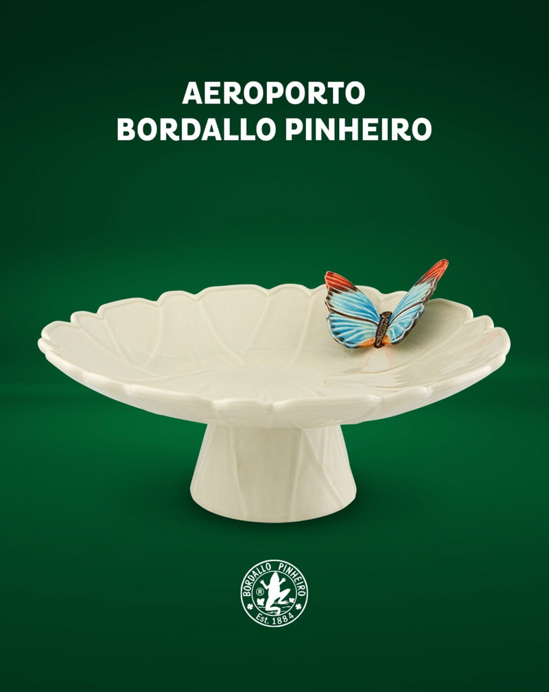 Decorative ceramic cake dish with a butterfly on a green background, featuring the Bordallo Pinheiro logo.
