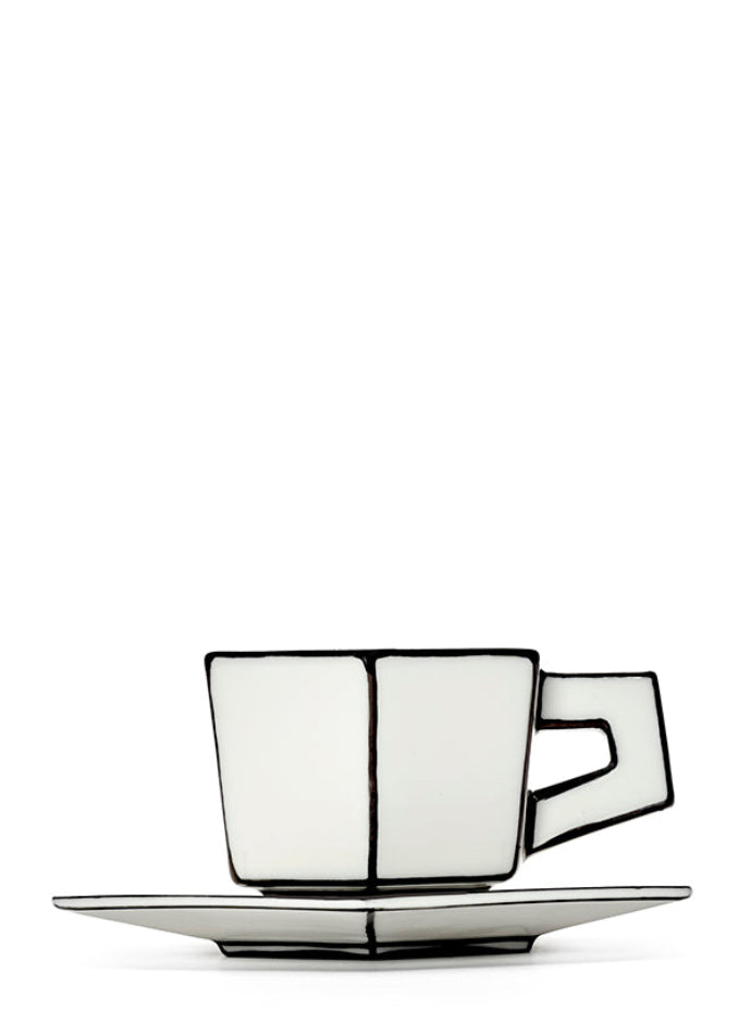 White ceramic espresso cup and saucer with black trim on a white background