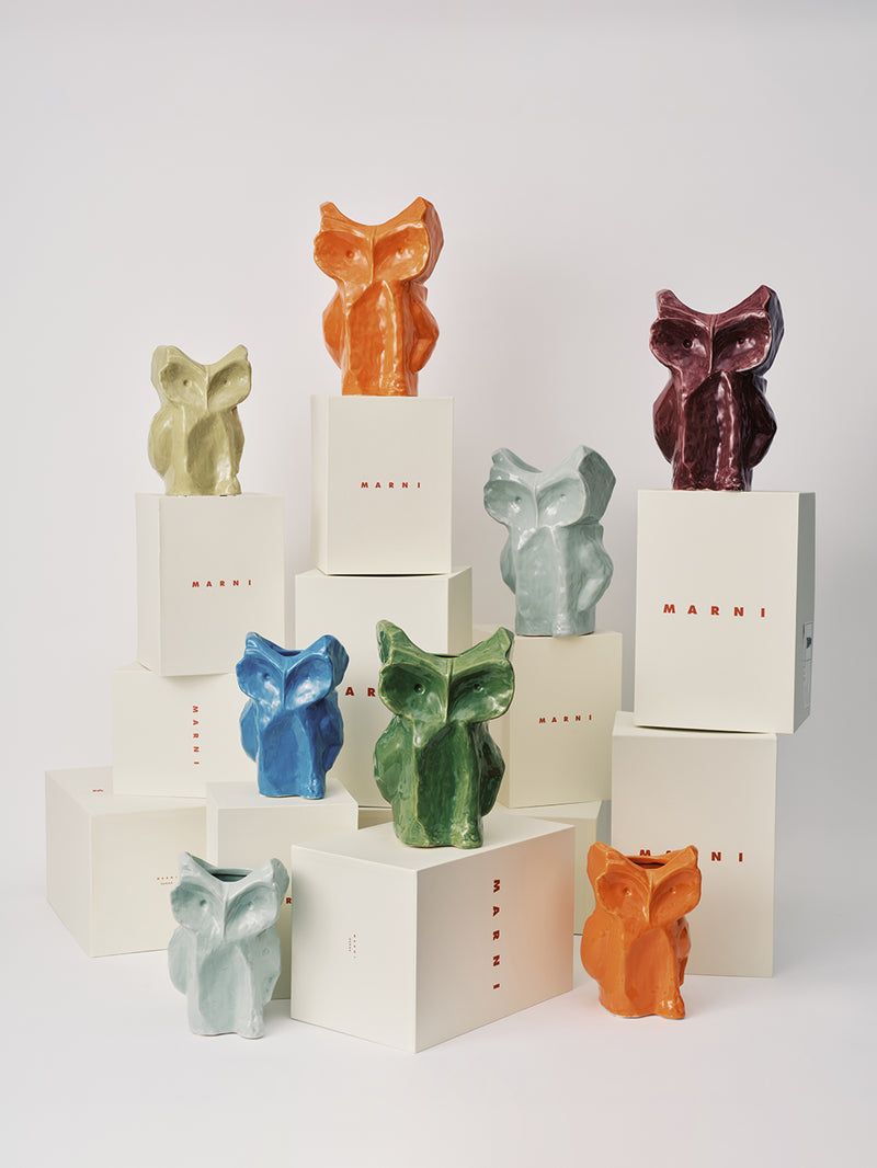Colorful owl-shaped vases on white boxes with 'Marni' branding against a light gray background.