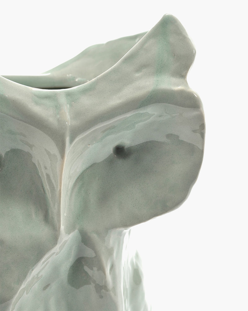 Abstract sculpture with smooth, flowing lines on a light background