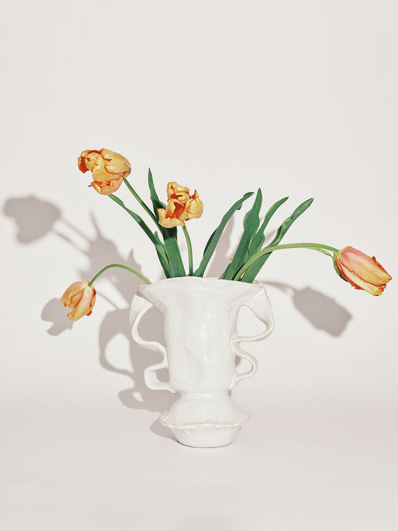White vase with tulips on a light background
