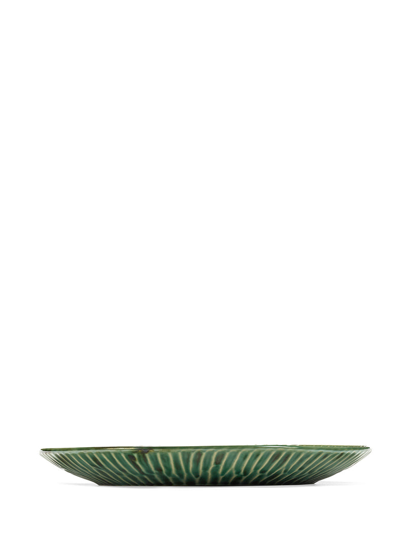 Green ceramic plate with decorative pattern on a white background