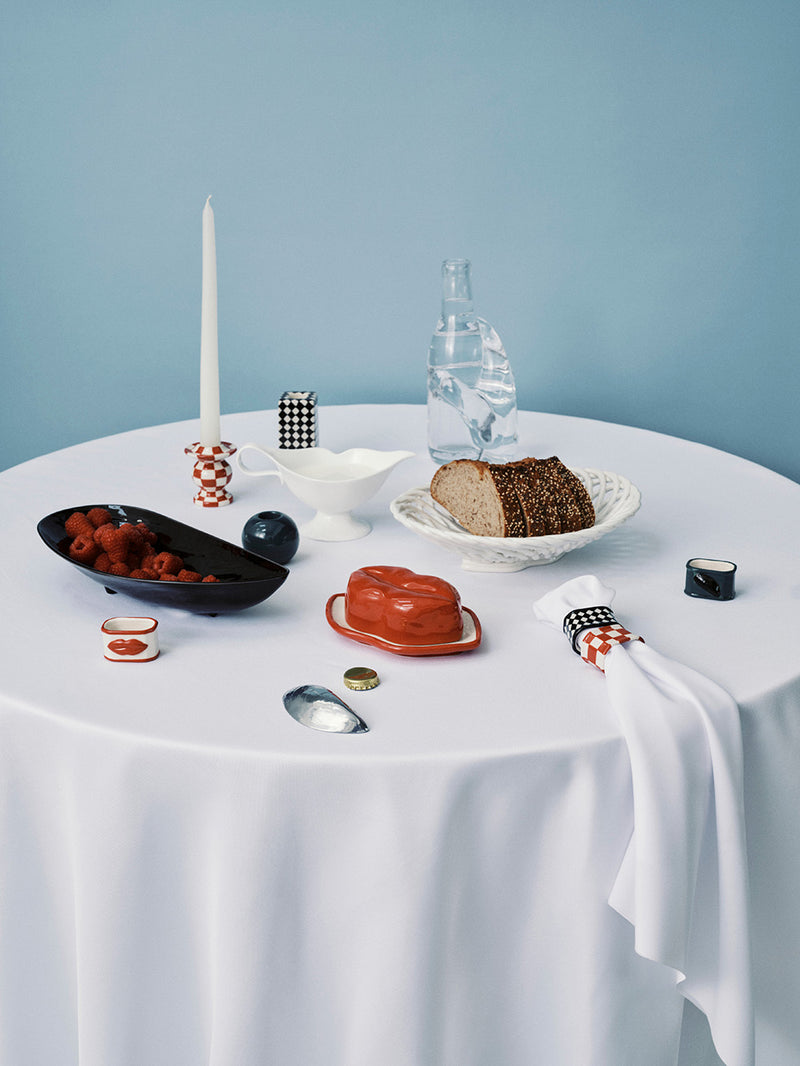 Round table setting with food and decor against a light blue wall