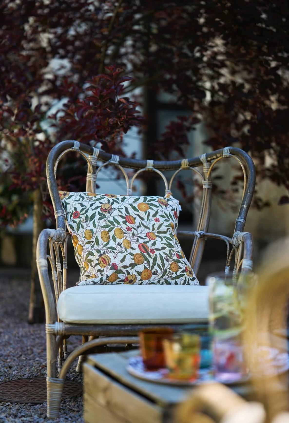Rattan chair with a floral printed pillow on a patio