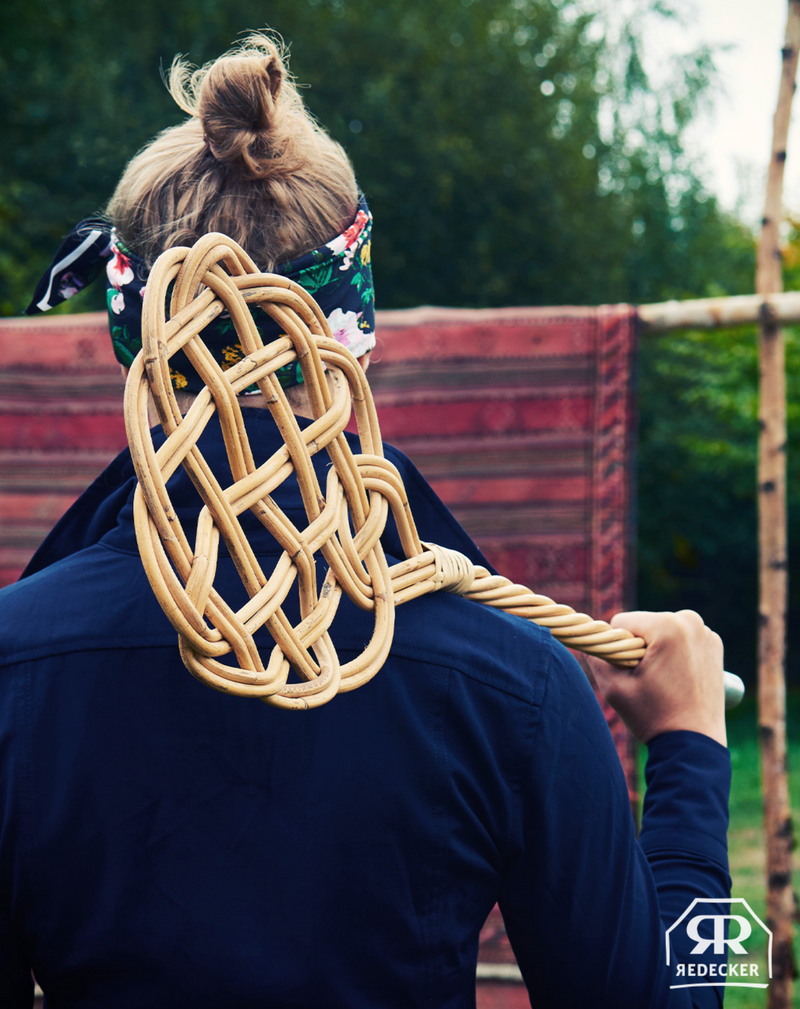 Person holding a large carpet  beater 