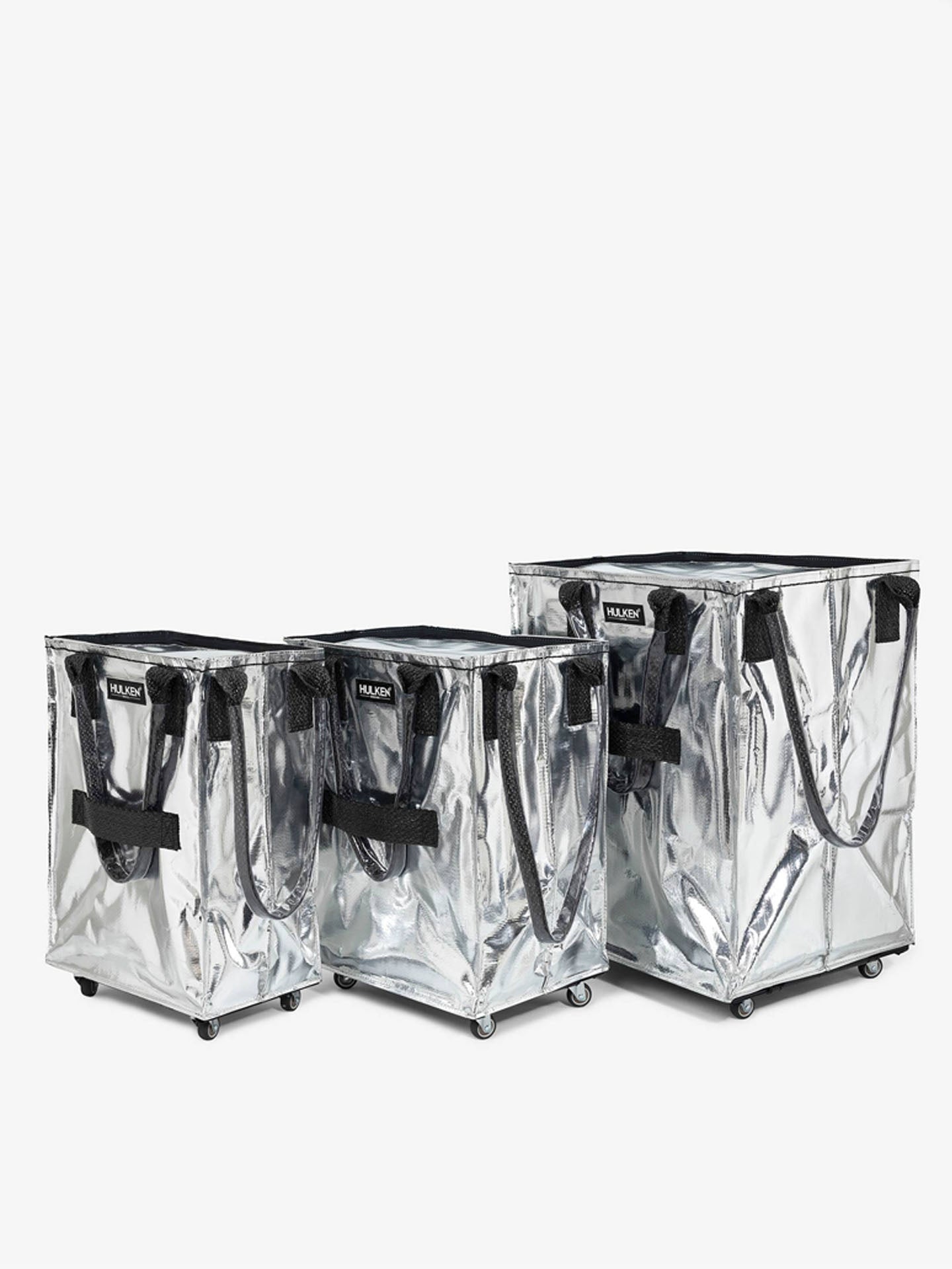 Three silver storage bags with wheels and black straps 