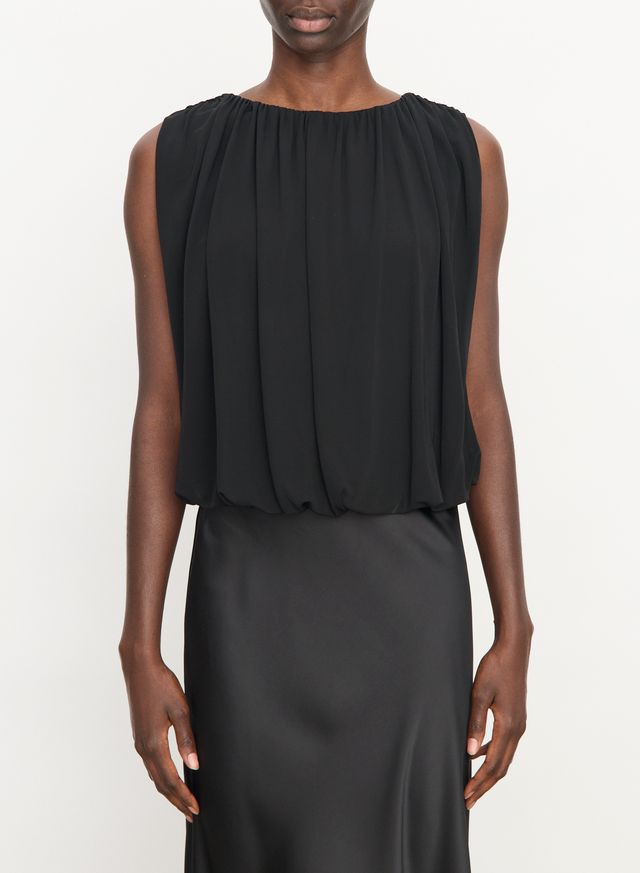 Black sleeveless top with bubble hem drapes softly from the shoulder's of the model to the models waist on a white background